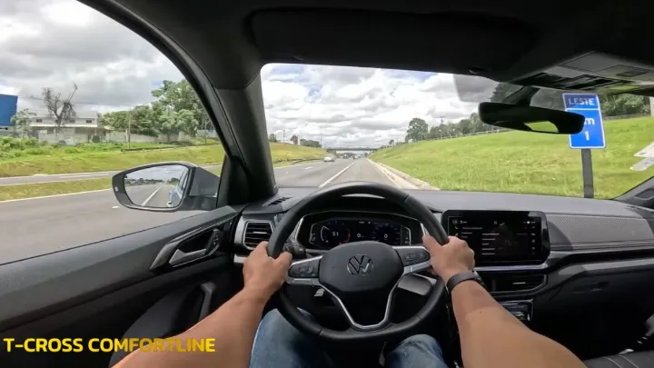Interior do T‑Cross com painel, volante e motorista dirigindo em 2025