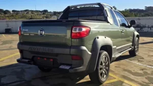 Fiat Strada usada para trabalho estacionada em frente a uma obra com ferramentas na caçamba