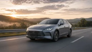 Sedã híbrido plug-in inspirado no BYD King circulando em rodovia brasileira ao amanhecer.
